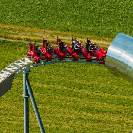Achteransicht einer Achterbahn mit Fahrgästen auf einer Kurve