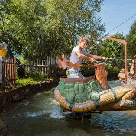 Kind spielt auf einer Krokodilattraktion im Wasserpark