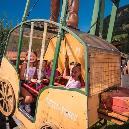 Kinder in einem farbenfrohen Fahrgeschäft im Erlebnispark