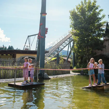 Kinder auf Plattformen in einem Freizeitpark über Wasser