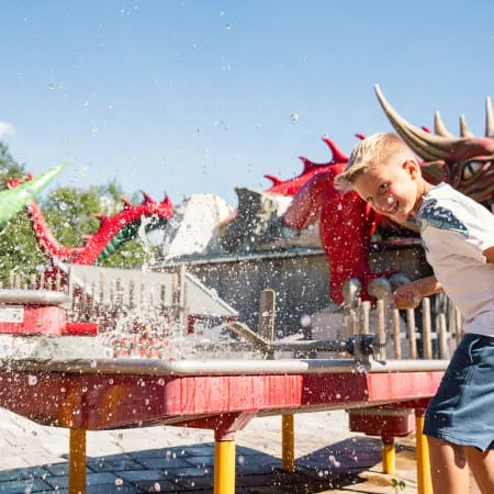 Junge spielt mit Wasser in Erlebnispark Familienland