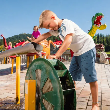 Kind spielt an Wasseranlage im Erlebnispark Familienland