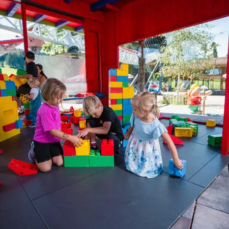 Kinder spielen mit bunten Bausteinen in einem Erlebnispark