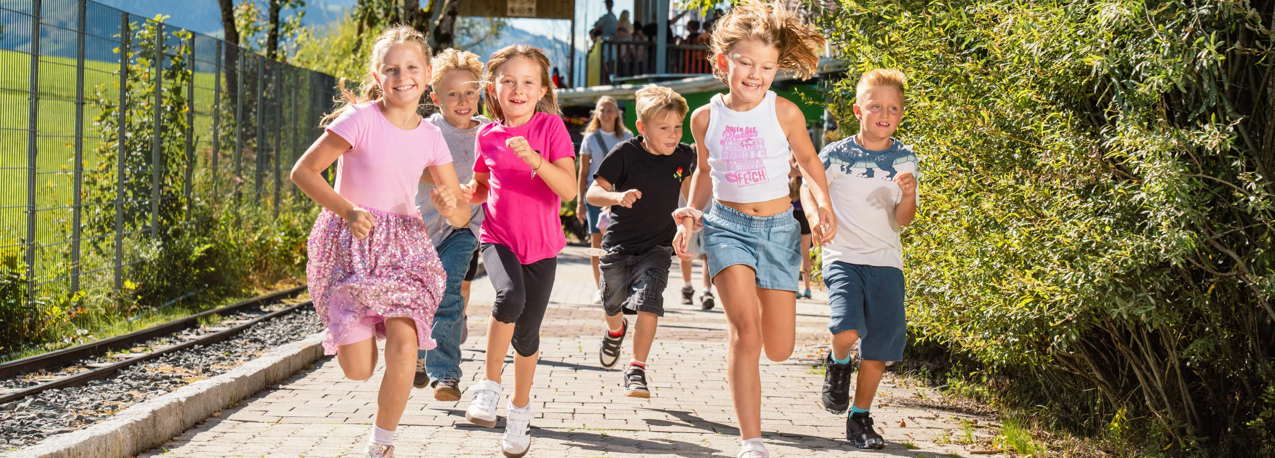 Gruppe von Kindern, die fröhlich in einem Freizeitpark rennen