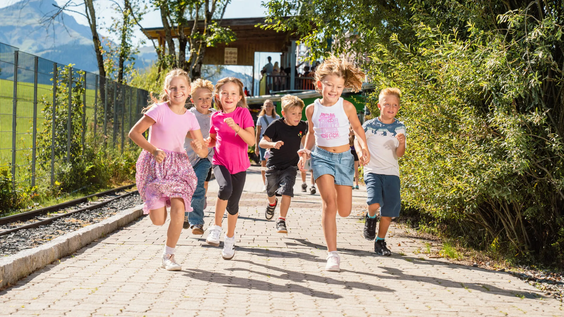 Gruppe von Kindern läuft fröhlich in einem Freizeitpark.